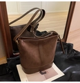 Dettaglio borsa a secchiello in pelle scamosciata marrone con cuciture in pelle - Marrone