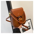 Detail of caramel brown mini bag featuring woven texture and vintage round buckle clasp - Woven Style / Brown