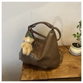 Macro detail of brown PU leather tote bag texture with plush bear and braided strap - Khaki With Pendant