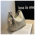 Detail of cream tote bag featuring textured leather, bear charm, and logo plaque - Cream White with Pendant