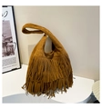 Dettaglio macro della borsa con frange marrone caramello con texture opaca e nappine boho - Marrone