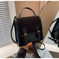 Dettaglio della patta nera testurizzata con fibbia dorata su una mini borsa elegante - Nero