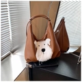 Detail van bruine PU-lederen hobo-tas met een witte pluche hond en metalen rits - Bruin