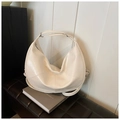 Detail of creamy white crescent hobo bag with glossy finish on a minimalist background - White
