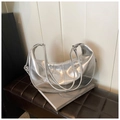 Detailed close-up of metallic silver crescent bag with textured faux leather on a stool - Silver