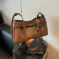 Coffee brown leather shoulder bag featuring a vintage gold twist lock and woven charm - Brown