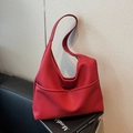 Große rote Tote Bag aus Leder mit Litschistruktur und breitem Gurt auf Zeitschriften - Burgunderrot