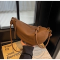 Detailed close-up of brown pebbled leather texture and knotted shoulder strap detail - Brown