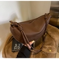 Detail of brown litchi leather bag with decorative knot strap and gold metal hardware - Coffee