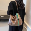 Grande borsa tote in pelle marrone con ciondolo smiley verde indossata su cappotto nero - Stile Con Ciondolo / Moka
