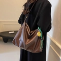 Grande borsa tote in ecopelle marrone scuro con ciondolo smiley indossata da modella - Stile Con Ciondolo / Marrone