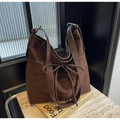 Détail du sac cabas en daim marron foncé avec nœud décoratif et boucle en métal argenté - café