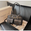 Dettaglio borsa sottobraccio vintage grigia con fibbie dorate in una confezione regalo - Nero