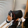 Black Boston barrel bag with striped strap and plush bear charm in soft lighting - Black With Pendant