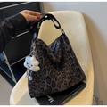 Dettaglio borsa tote con stampa leopardata, tracolla nera e ciondolo a nuvola di peluche - Marrone Scuro