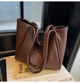 Nahaufnahme der dunkelbraunen Ledertextur und des gefalteten Designs dieser Shopper-Tasche - Braun