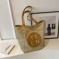 Minimalist beige canvas tote bag with brown leather handles and circular logo patch - No Pendant / Khaki