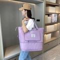 Purple large capacity travel tote bag with expandable bottom shown on model's shoulder - Purple