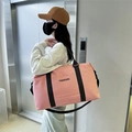 Pink large capacity oxford travel bag with black straps being held by a model - Pink