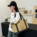 Khaki travel duffel bag with black straps and trolley sleeve shown in lifestyle setting - Khaki