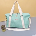 Detail of mint green travel bag featuring bubble texture and fringe zipper puller - Aqua Green
