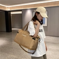 Large capacity beige lightweight travel duffel bag with adjustable strap shown on model - Khaki