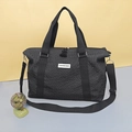 Sac de voyage noir avec texture matelassée, poignées et bandoulière réglable - Noir