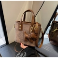Detail of vintage brown canvas handbag with leather trim and decorative puppy charm - Coffee with Pendant