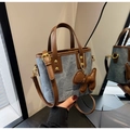 Detail of blue denim bucket bag with brown leather trim and cute puppy charm accessory - Blue with Charm