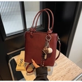 Dettaglio della borsa a secchiello bordeaux in pelle PU con ciondolo a tema baseball - Con Pendente da Baseball / Borgogna