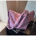 Macro shot of purple nylon shoulder bag with pleated scrunchie strap on desk - Purple