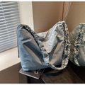 Detail of light blue cloud-shaped shoulder bag featuring elegant pleated strap design - Blue