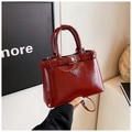 Deep red glossy patent leather handbag with triangle metal badge and adjustable shoulder strap - Red