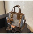Detail van blauwe denim mini bucket bag met bruine lederen bies en puppy hanger - Blauw Denim (Blauw Met Bedel)