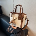 Minibolsa tote en beige y marrón con correa ajustable y un bonito colgante de mono - Blanco y café con colgante