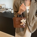 Bolso de mano de cuero marrón con asas dobles y un colgante de mono de peluche - Café con Colgante