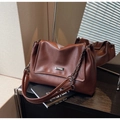Detailansicht dunkelbraune Schultertasche aus Kunstleder mit Goldkette und Marken-Plakette - Braun