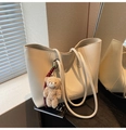 Détail d'un sac cabas beige grainé avec un pendentif ours en peluche sur table - Avec Pendentif / Blanc