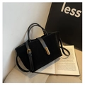 Close-up of black frosted tote bag with gold metal clasp and premium smooth leather handles - Black
