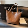 Detailaufnahme der dunkelbraunen Leder-Shopper-Tasche mit feinen Nähten auf Sofa - Braun