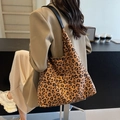 Sac fourre-tout léopard chic avec bandoulières en cuir noir porté par un mannequin - Marron