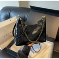 Detail of black quilted patent leather bag with gold chain and glossy diamond texture - Black