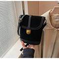 Vue détaillée du sac seau noir en daim avec un logo d'ours en métal doré élégant - Noir