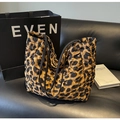 Vista dettagliata della borsa tote trapuntata leopardata su un divano in pelle - Marrone