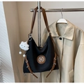 Detail der Nylon-Einkaufstasche mit braunem M-Logo aus Leder und weißem Plüschanhänger - Schwarz mit Anhänger