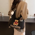 Black canvas tote bag with STRONG embroidery and plush cloud charm worn by model - With Pendant / Black
