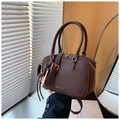 Close-up of retro brown leather bowling bag with gold logo and baseball keychain - Coffee with Pendant