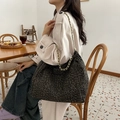Bolso tote con estampado de leopardo y cadena dorada llevado por una modelo en café - Verde Frijol