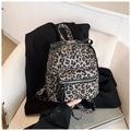 Détail d'un mini sac à dos à imprimé léopard avec nœud noir décoratif et fermeture éclair argentée - Marron