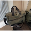 Detail der strapazierfähigen armee-grünen Reisetasche mit schwarzen Trägern und Reißverschluss - Grün